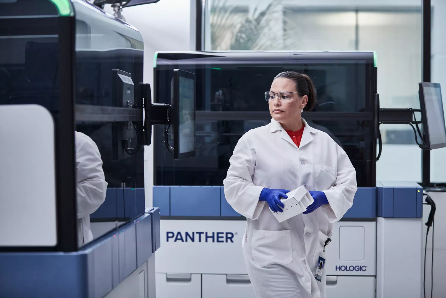 Technicien de laboratoire se déplaçant au milieu de systèmes Panther dans un laboratoire