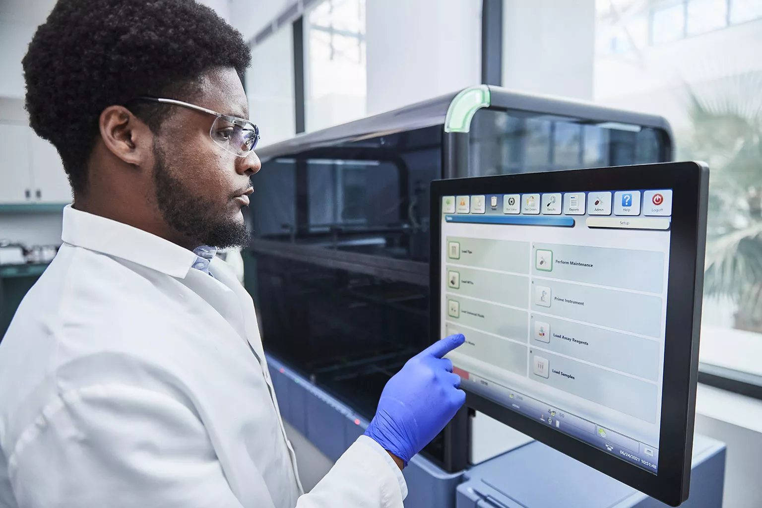 Médecin touchant l’écran d’un système Panther dans un laboratoire.