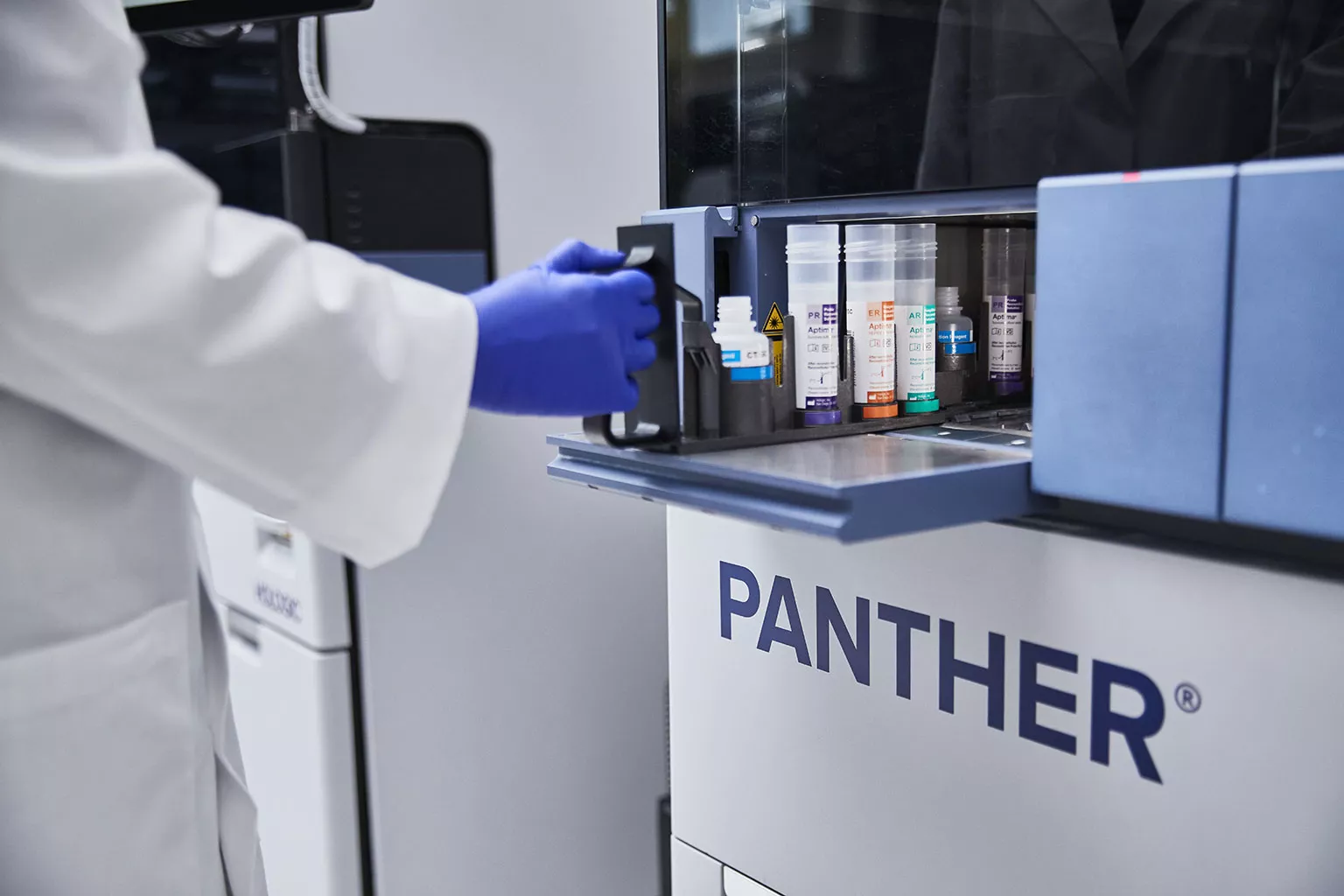 Une technicienne de laboratoire travaille avec un plateau de tubes dans un laboratoire.
