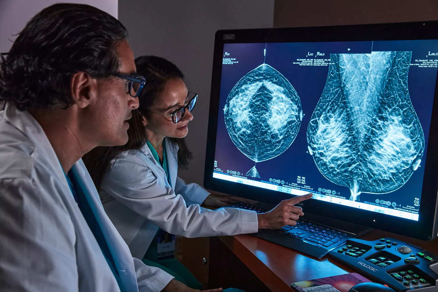 Professionnel de santé montrant l’image d’un scanner mammaire sur un écran