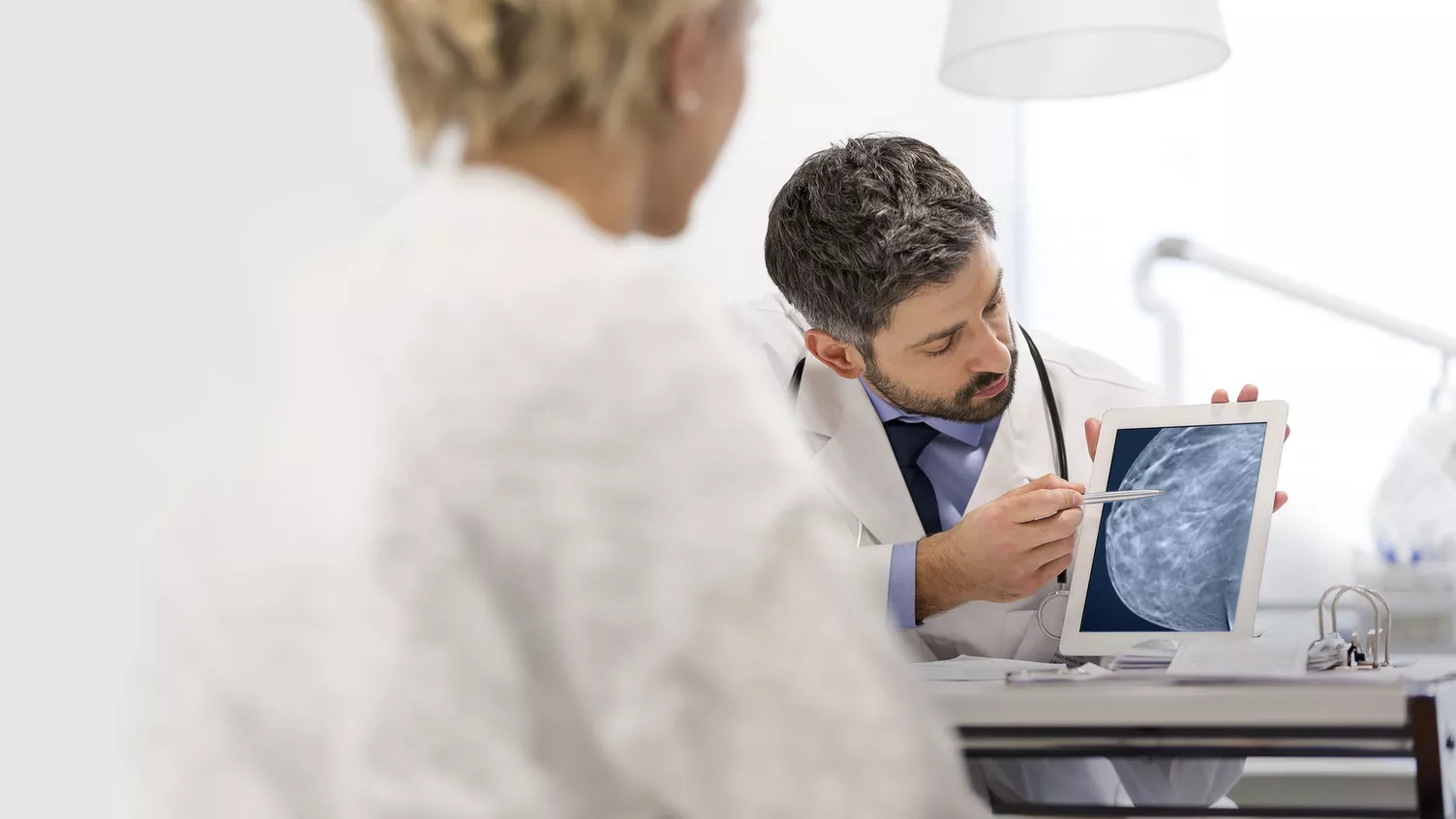 Technicien clinique montrant un examen mammaire sur un dispositif