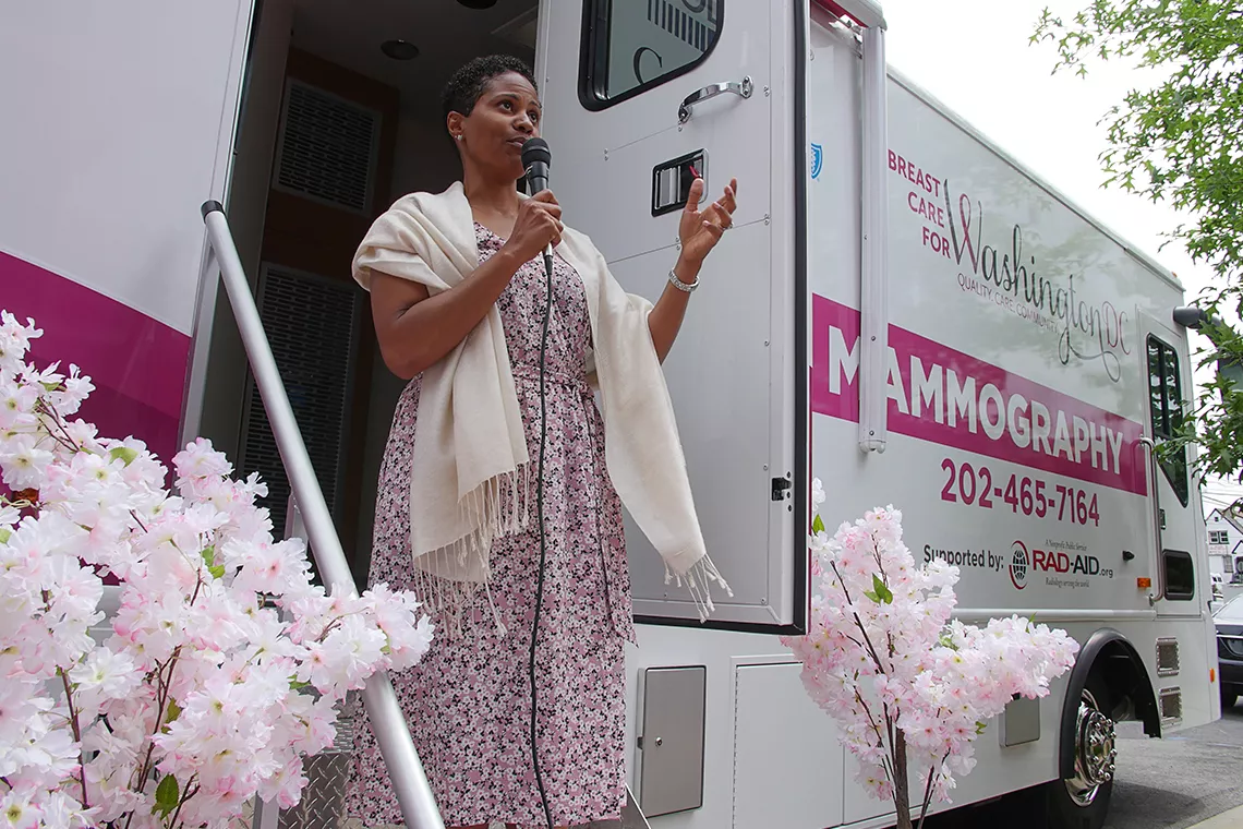 Femme noire parlant au micro devant le bus MobileMammo