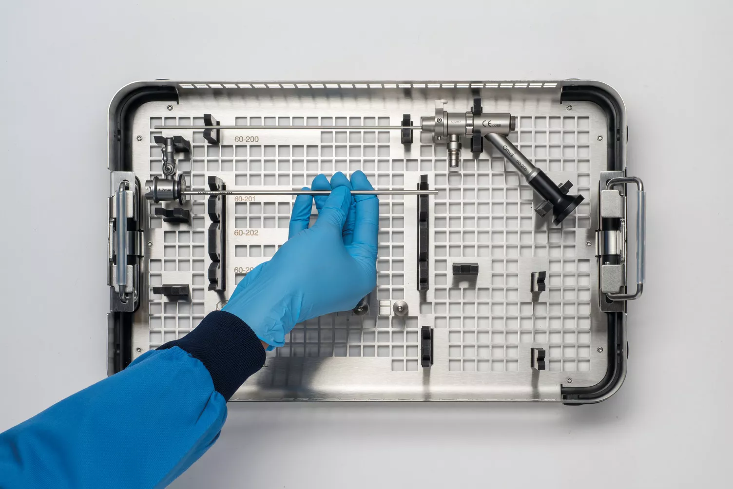 Main gantée travaillant sur un plateau médical posé sur une table.