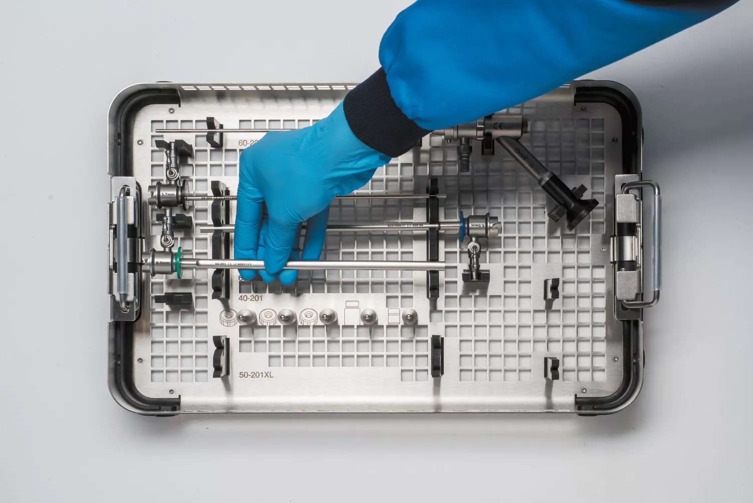 Main gantée travaillant sur un plateau médical posé sur une table.