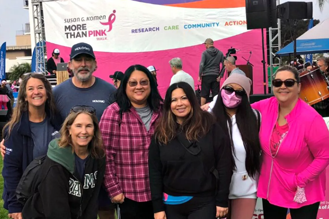 Photo de groupe d’hommes et de femmes souriants lors de la marche Susan G. Komen Race for the Cure