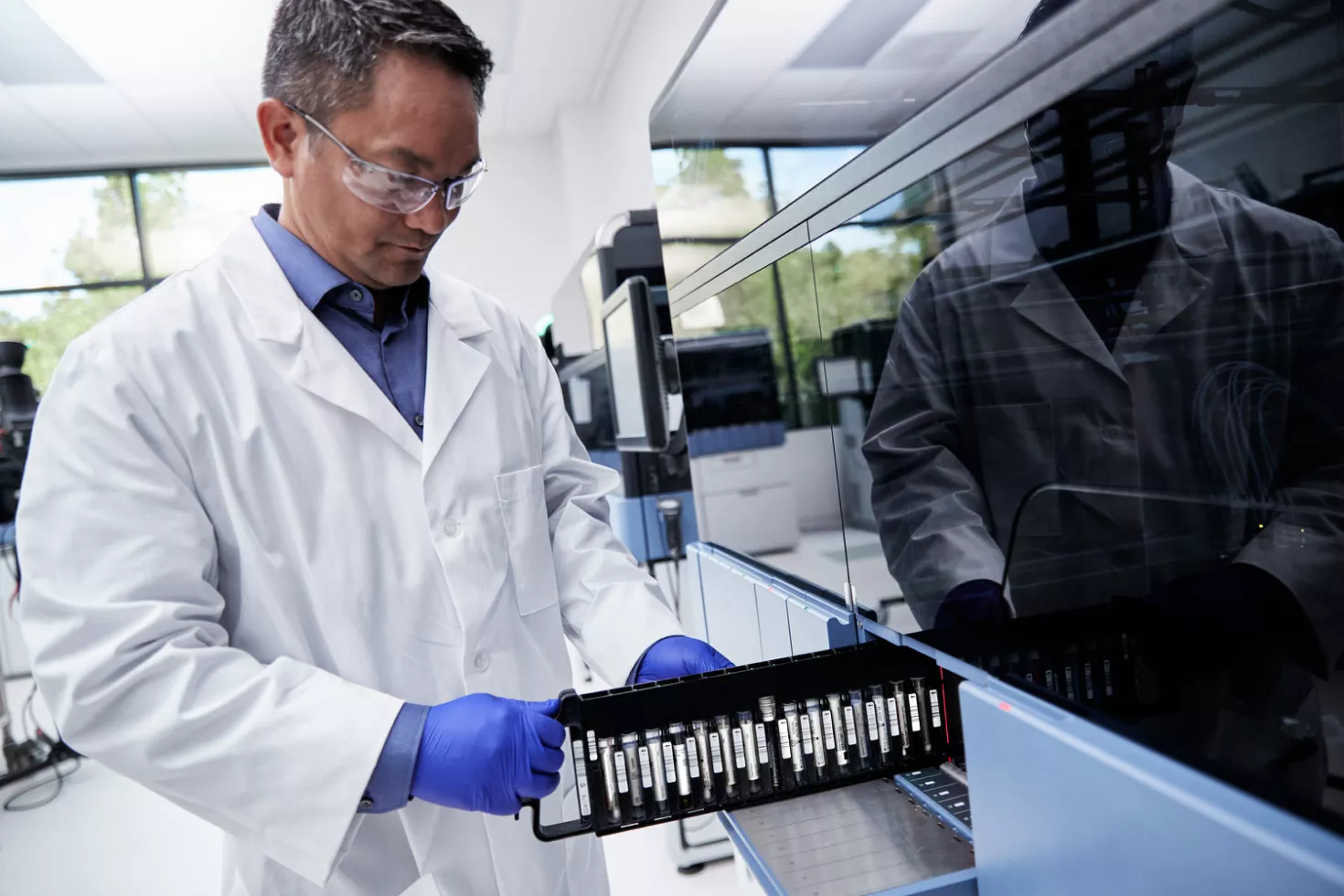 Technicien de laboratoire plaçant des tubes à essai dans un système
