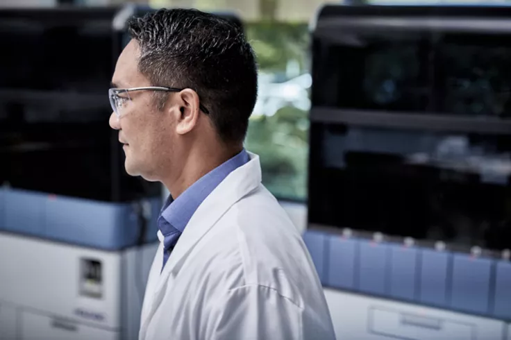 Vue latérale d’un technicien de laboratoire entouré de dispositifs médicaux