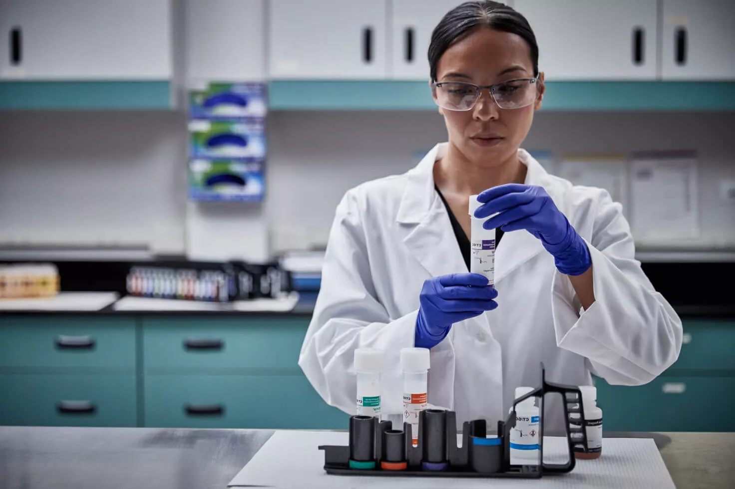 Technicienne de laboratoire tenant un kit de prélèvement par écouvillon dans un laboratoire